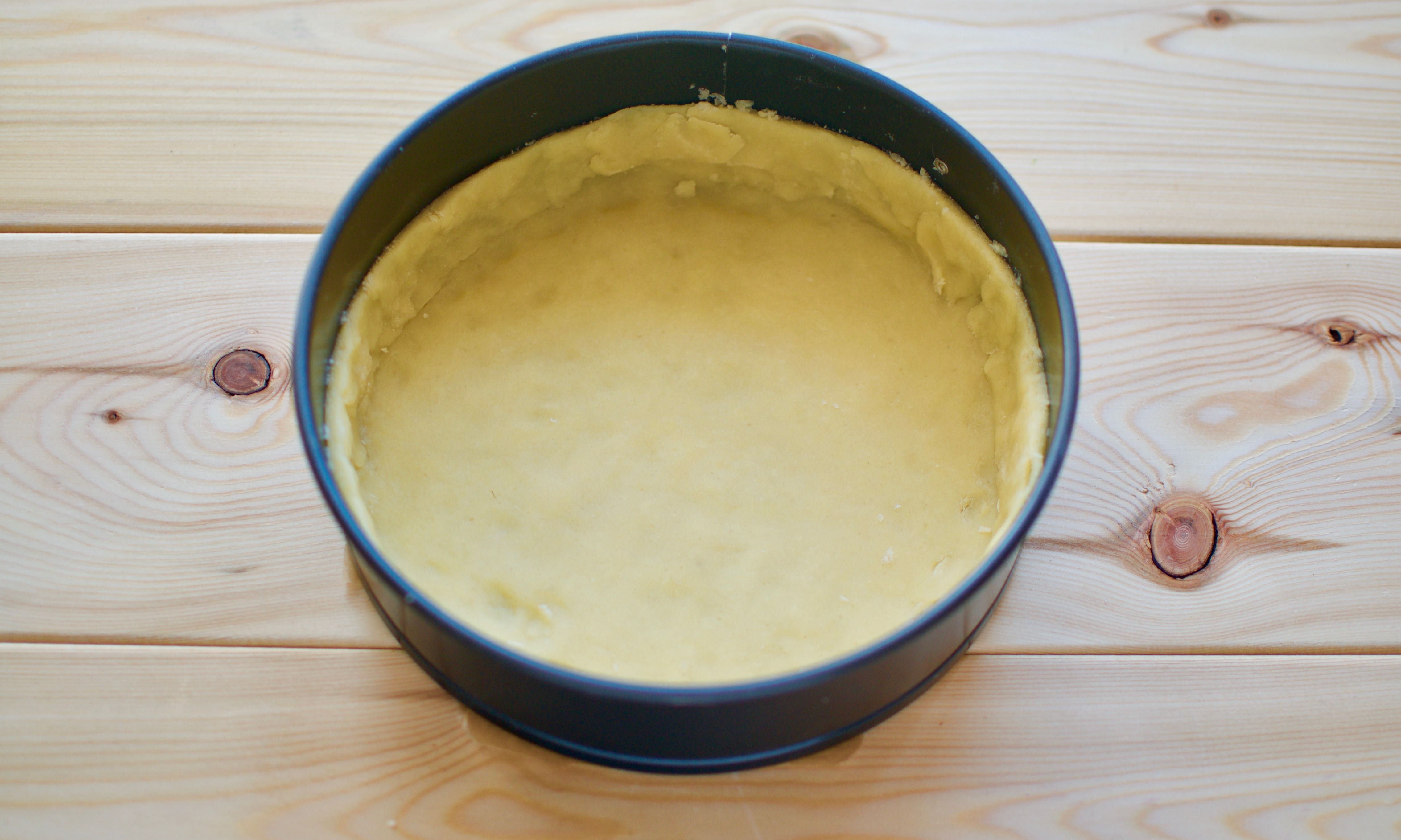 Положить тесто в масло. Песочная основа для пирога. Тесто в миске. Тесто в разъемной форме. Тесто в круглой форме.